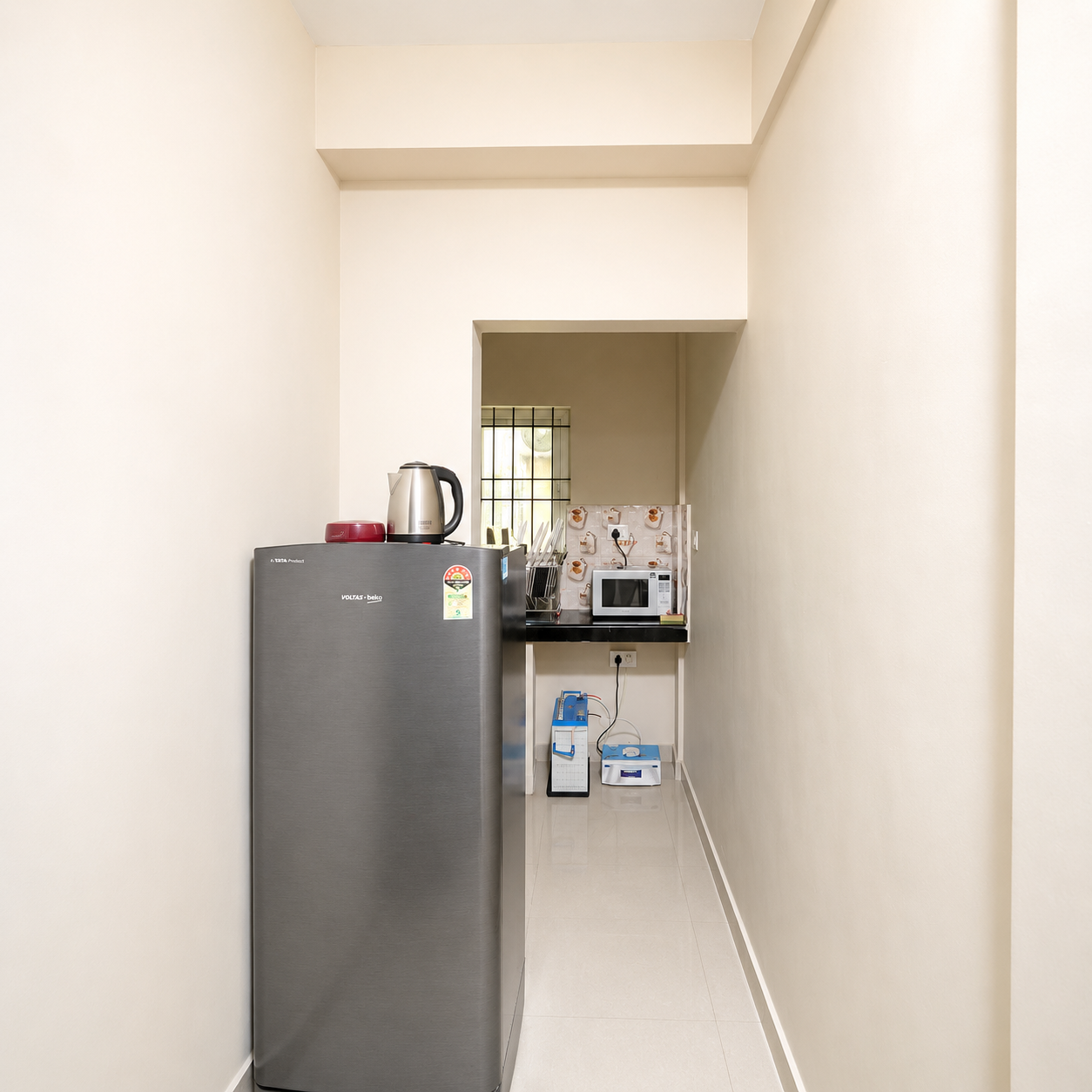 Kitchen corridor and refrigerator at Hima Havens Guruvayur Homestay